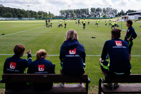 Delar ur ledarstaben tittar när spelarna värmer upp