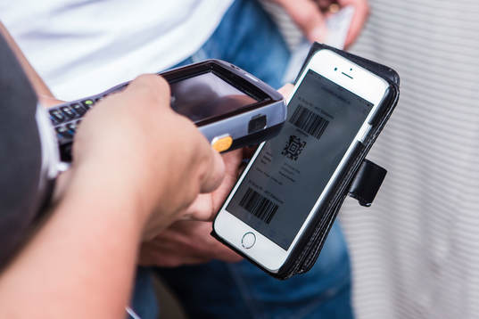 En biljett i mobilen scannas innan fotbollsmatchen i