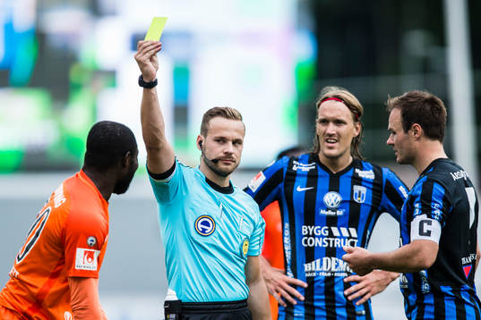 Domare Kristoffer Karlsson delar ut ett gult kort till AFC
