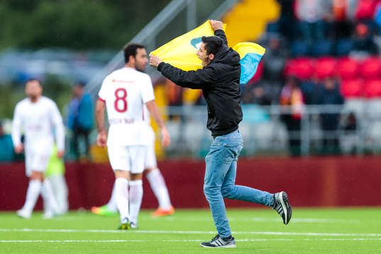 Person stormar planen med en flagga