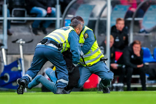 Person brottas ner av vakter