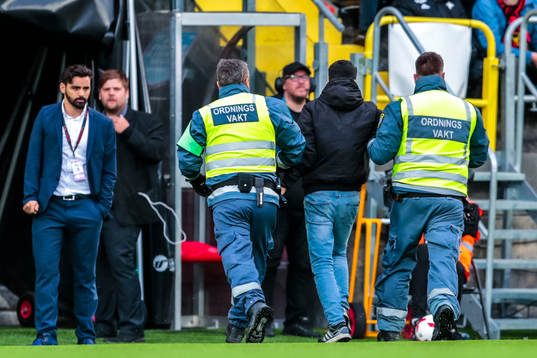 Person brottas ner av vakter