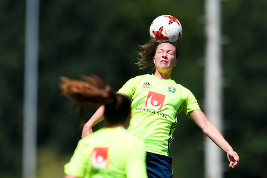 Pauline Hammarlund nickar en boll på en träning med det