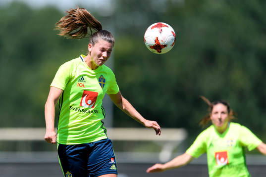 Pauline Hammarlund nickar en boll på en träning med det