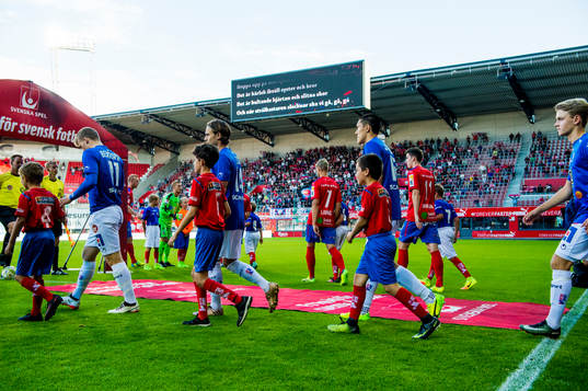 Spelarna kommer ut på planen till fotbollsmatchen i