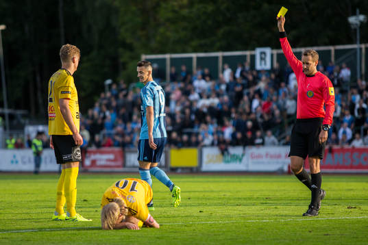Domare Victor Wolf delar ut ett gult kort till Haris