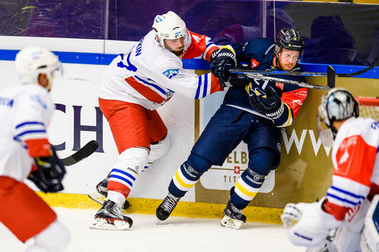 Thomas Larkin of Adler Mannheim hits Mattias Tedenby of HV71