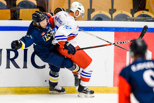 Brent Raedeke of Adler Mannheim hits Alexander Ytterell of