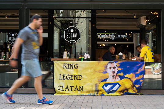 En man passerar ett svenskt fan med en banderoll med en