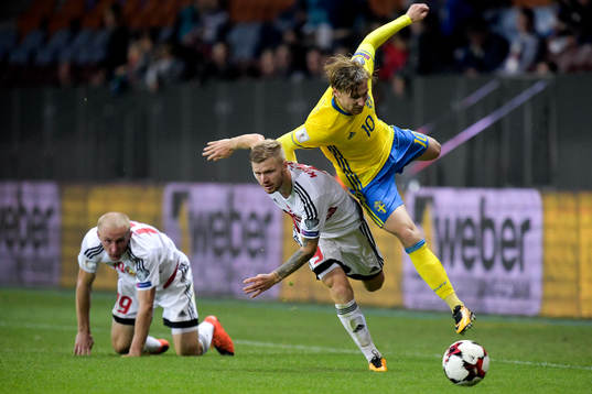 Belarus Nikita Korzun tacklar Sveriges Emil Forsberg