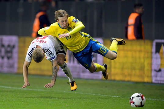 Belarus Nikita Korzun tacklar Sveriges Emil Forsberg