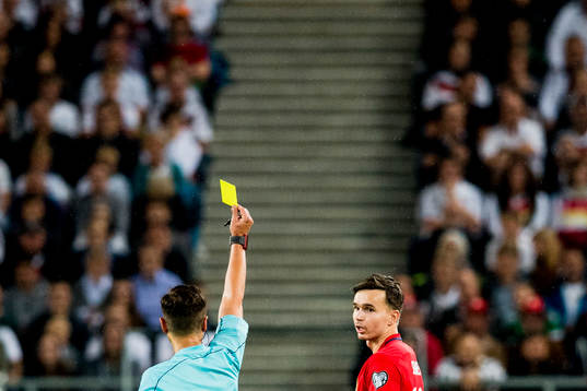 Ole Kristian Selnæs of Norway receives a yellow card