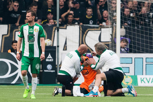 Hammarbys läkarteam tar hand om målvakt Johan Wiland som