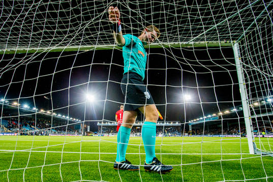 An assistant referee makes a check of the net
