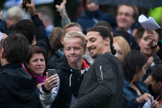 Zlatan Ibrahimovic tar en bild med en ung supporter