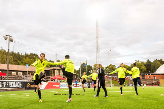 Brommapojkarnas spelare värmer upp före fotbollsmatchen i