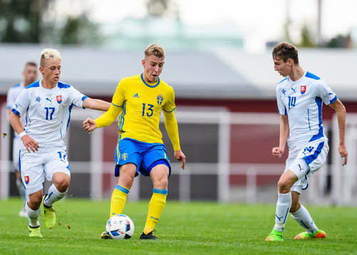 Sveriges Amel Mijanic med bollen jagas av Slovakiens