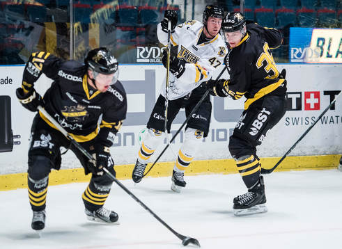 s Simon Fernholm med pucken framför Anton Holm och