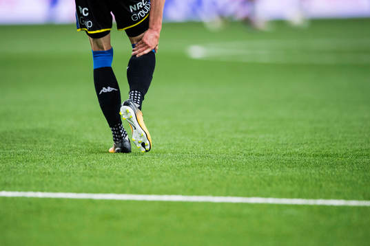En fotbollsspelare tar sig för vaden