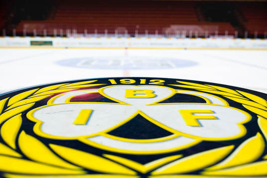 Brynäs klubbmärke på ett bord framför rinken
