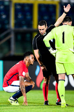 Joshua King of Norway sitting down with an injury and