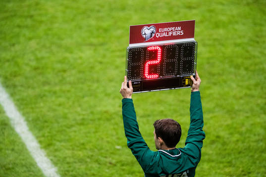 Fjärdedomaren håller upp en skylt som presenterar
