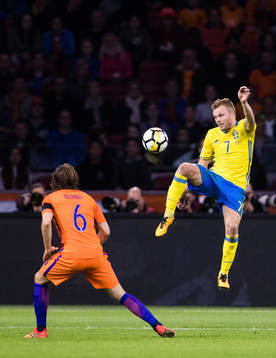 Sveriges Sebastian Larsson rensar undan bollen framför