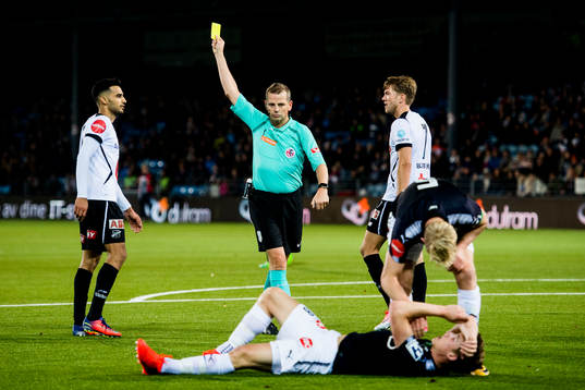 Trygve Kjensli, referee, gives a yellow card to Etzaz