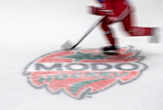 En Modospelare åker förbi Modos klubbmärke