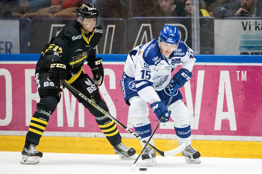 s Simon Fernholm i kamp om pucken i ishockeymatchen i