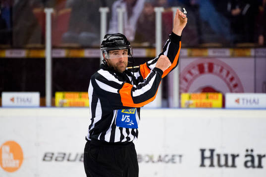 Domare Mikael Sjöqvist signalerar spel med hög klubba