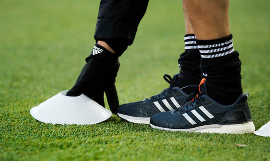 En person lägger ut konor före fotbollsmatchen i