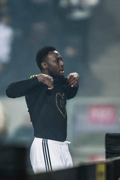 s Chinedu Obasi jublar och visar en en tshirt tillägnad
