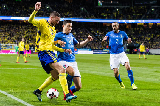 Sveriges Marcus Berg i kamp om bollen med Italiens Matteo