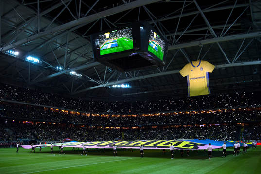 En sverigetröja hänger i taket på Friends Arena innan
