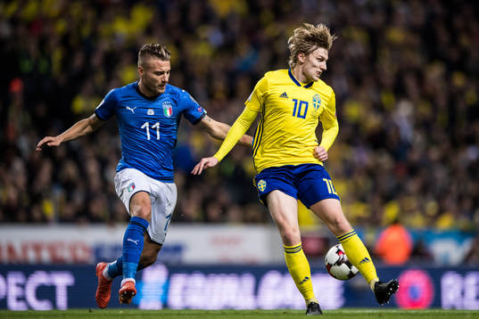 Sveriges Emil Forsberg klackar bollen bredvid Italiens Ciro
