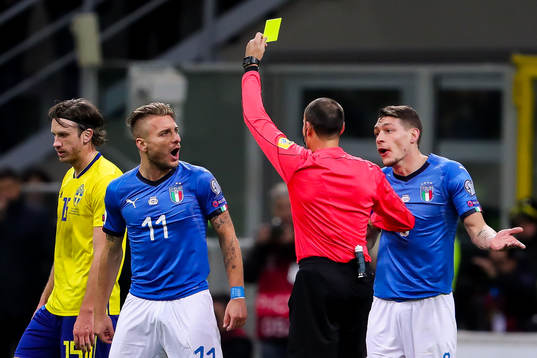 Italiens Ciro Immobile får gult kort av domare Antonio