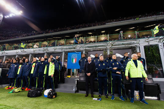 De svenska spelarna på bänken sjunger nationalsången