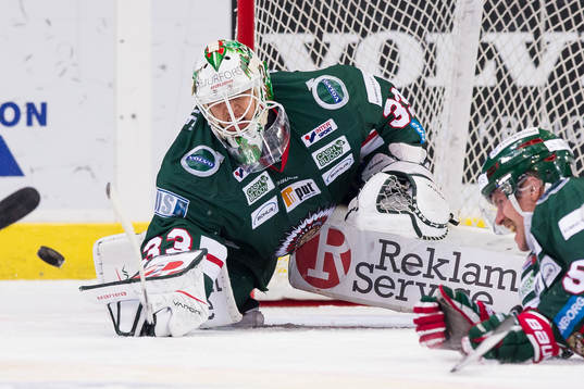 Frölundas målvakt Johan Mattsson stöter bort pucken med