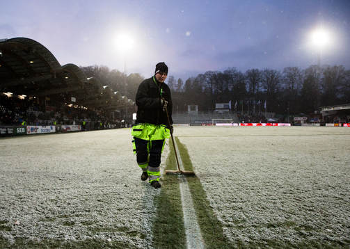 En vaktmästare borstar bort snö från planen