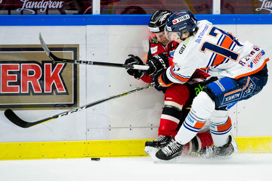 Malmö Redhawks Johan Olofsson trycks till av Växjös