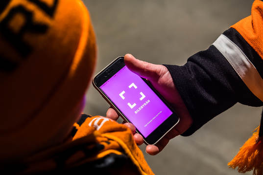 man visar Bildbyråns app