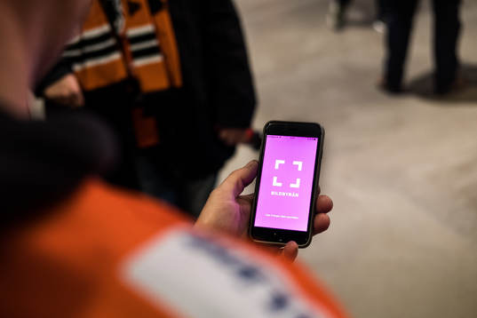 man tittar på Bildbyråns app