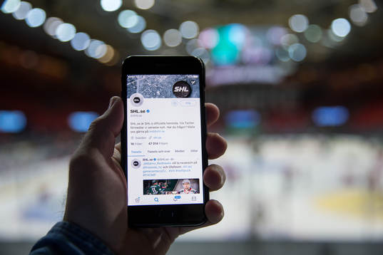 s twitter på sin mobil innan ishockeymatchen i SHL mellan