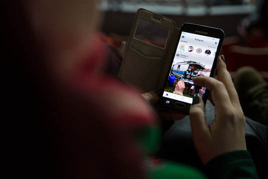 En supporter tittar på Frölundas Instagram på sin mobil