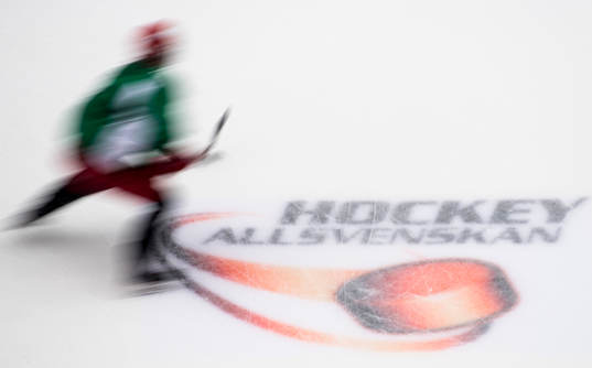 En spelare åker förbi Hockeyallsvenskans logotyp innan