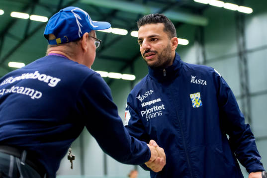 Nya tränaren Poya Asbaghi hälsar på en supporter