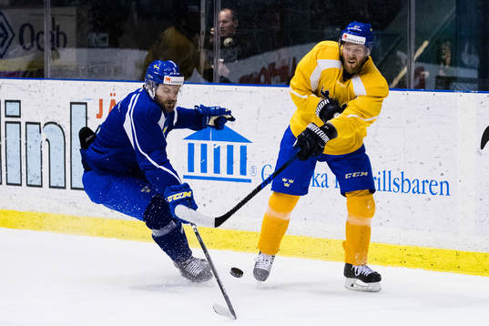Sveriges Mikael Wikstrand i kamp om pucken med Linus Omark