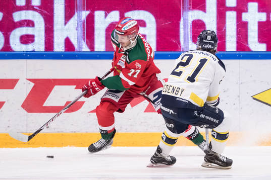 s Mattias Tedenby i kamp om pucken i ishockeymatchen i SHL
