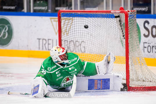 Rögles målvakt Justin Pogge följer pucken in i mål